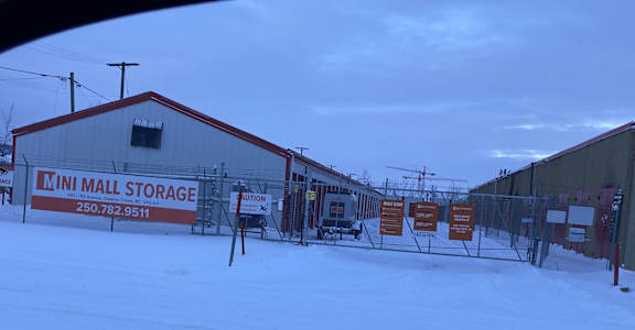 a building with a fence and signs in the snow